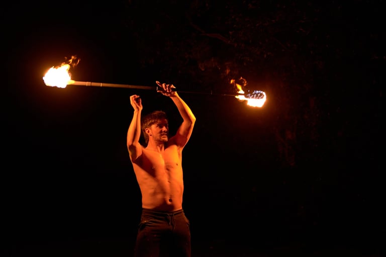 Fire performer holding burning staff